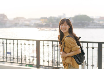 Wall Mural - young Asian woman in 30s on a solo adventure. Technology in hand, she captures the essence of cultural exploration and joyful discovery.