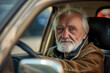 © J S - A senior old driver in a car, looking out of the driver's side open window