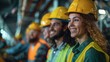 © Pavel - A group of smiling construction workers in yellow helmets and green reflective vests, standing side by side with their faces directed