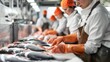 © amonrat - Production line of people who fillet fish in a factory