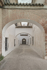 Wall Mural - A hallway with whitewashed walls in a monumental building with brick facades and large arcades with terracotta roofs