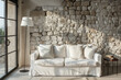 © Lucas - White sofa with beige pillows and floor lamp against window near stone cladding wall. Mediterranean home interior design of modern living room.