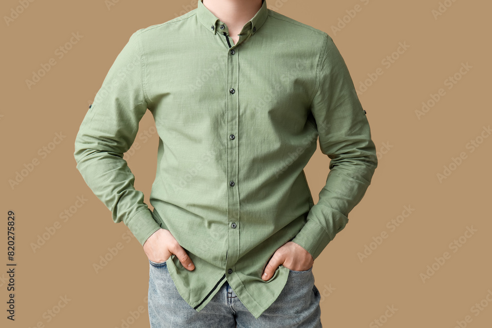 Young man in stylish green collar shirt on brown background