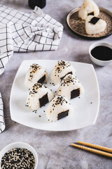 Poster - Homemade onigiri rice balls with tuna and nori on a plate on the table vertical view