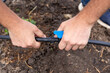 © Natalia - Installation of a drip irrigation system for the garden. A man connects a shut-off valve to an HDPE pipe to shut off the water