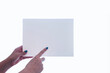 © Luis G. Vergara - Woman's hand holding a small blank board with a finger aiming to it, on white background with copy space.
