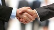 © sunthon - Close-up of two businesspeople shaking hands, signifying agreement, partnership, or successful deal in a professional setting.