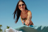 Fototapeta  - Beautiful girl setting up her towel on a beach.