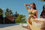 Fototapeta  - Lean girl in a swimsuit kneeling and enjoying the sun