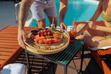 Fototapeta  - Tattooed man serving a tray of fresh fruits and drinks