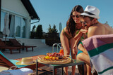 Fototapeta  - Affectionate couple at a resort looking at their fruit breakfast