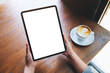 © Farknot Architect - Mockup image of a woman holding digital tablet with blank white desktop screen in cafe