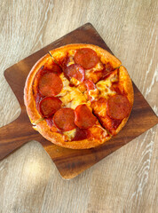 Poster - Pizza with sausage and tomatoes on a wooden board