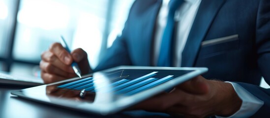 A businessman expertise in business and financial analysis, using a tablet in a modern office. Showing data analysis skills and proficiency in using technology for financial tasks