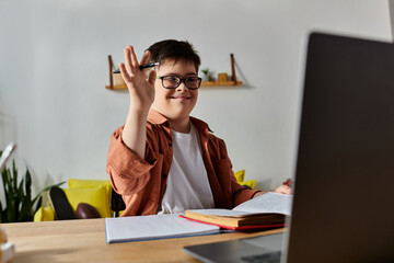 Wall Mural - boy with Down syndrome at home desk using laptop.