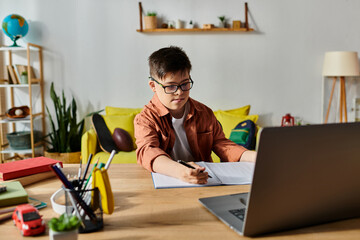 Wall Mural - A adorable boy with Down syndrome focused on his laptop at home.