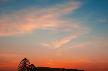 Wall Mural - Vibrant sunset over a picturesque landscape of fields and clouds