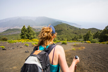 Wall Mural - A young woman walking towards Birigoyo peak, La Palma Island, Canary Islands.