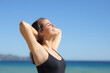 © PheelingsMedia - Happy woman showing waxed armpit breathing on the beach