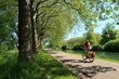 © Florence Piot - Cyclotourisme dans la campagne, sur une piste cyclable bordée d’arbres, au bord du canal de Bourgogne à Dijon, en Côte d’Or, paysage de nature avec une femme cycliste sur un vélo de randonnée (France)