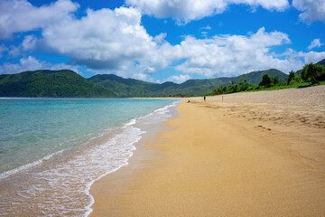 Wall Mural -  Beautiful sandy beach stretching along the turquoise waters in Lombok, Indonesia, under a clear summer sky