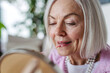 © Halfpoint - Skincare for mature woman. Portrait of beautiful older woman with gray hair putting makeup on.