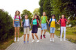 © Studio Romantic - Happy students playing and having fun in a green park. Cheerful school friends with backpacks playing games outdoors. Group of joyful children in comfortable casual clothes holding hands and jumping