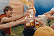 © Jacob Lund - Friends raise their beers in a celebratory toast, capturing a moment of festival fun