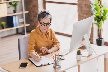 Sticker - Photo of pretty retired woman signing contract dressed yellow formalwear modern workplace working home distance office