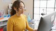 © Krakenimages.com - A young woman focuses on a computer screen in a well-lit laboratory setting, embodying professionalism.