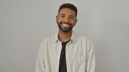 A smiling young black man with a beard posing casually against a white background, exuding confidence and style.
