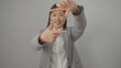 © Krakenimages.com - A young asian businesswoman in a gray suit makes a frame gesture with her hands against a white background.