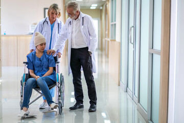 Wall Mural - Professional medical doctor team with stethoscope in uniform discussing with patient woman with cancer cover head with headscarf of chemotherapy cancer in hospital.health care concept