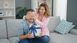 © Krakenimages.com - Man and woman couple surprised with birthday gift at home