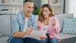 © Krakenimages.com - Man and woman couple reading document celebrating at home
