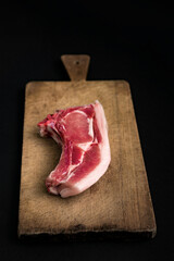 raw meat on wooden board and black background