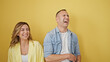 © Krakenimages.com - Man and woman couple standing together laughing a lot over isolated yellow background