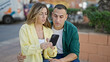 © Krakenimages.com - Man and woman couple using smartphone worried at park