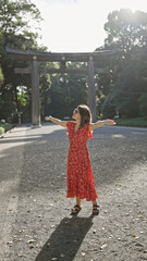 Poster - Joyful hispanic woman smiling with open arms, looking around at meiji temple, showcasing confidence and happiness