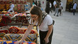© Krakenimages.com - A young adult brunette woman examines colorful textiles at souq waqif marketplace in doha, qatar.