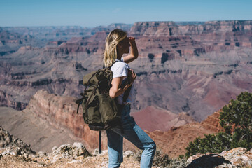 Wall Mural - female traveler with backpack enjoying trip while hiking on touristic route in wild environment, hip