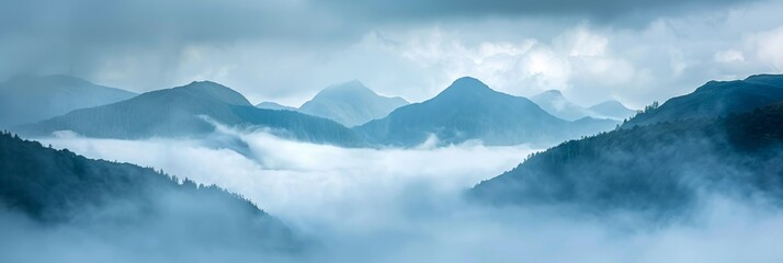 Wall Mural - Soft fog drifts through mountain valleys under a cloudy sky.