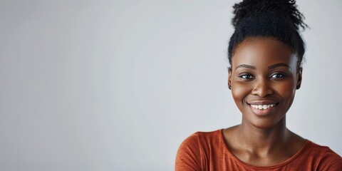 smiling black woman with dark skin in casual attire on light backgroun