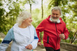 © master1305 - Sport inspirational. Happy smiling elderly people, man and woman in sportswear jogging in public park in early morning. Concept of sport, aging, active and healthy lifestyle, health care