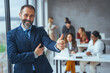 © Dragana Gordic - Successful business man smiling in a creative office. Portrait of happy mature man looking at camera indoor. Man with beard feeling confident. Close up face of hispanic business man smiling.