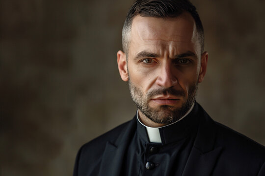 Handsome man catholic priest in black clothes on dark background