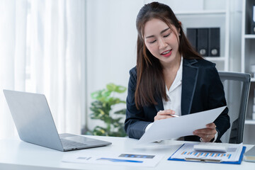 happy young businesswoman Asian siting on the chiar cheerful demeanor raise holding coffee cup smiling looking laptop screen.Making opportunities female working successful in the office.	