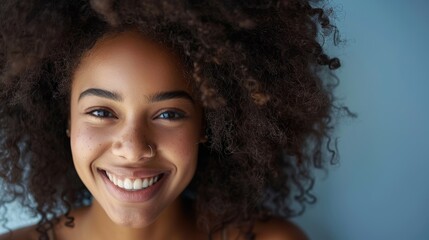 The image shows an attractive black girl with lush curly hair posing for a fashion magazine photoshoot with playful facial expressions. Portrait shot taken at a professional studio.