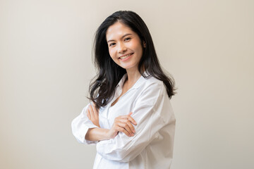 Poster - Smile positive, happy asian young woman wearing casual shirt, portrait of beautiful female with black long hair feeling prond, standing crossed arms looking at camera, isolated on white background.