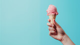 Fototapeta  - Hand holding ice cream on blue background with copy space.